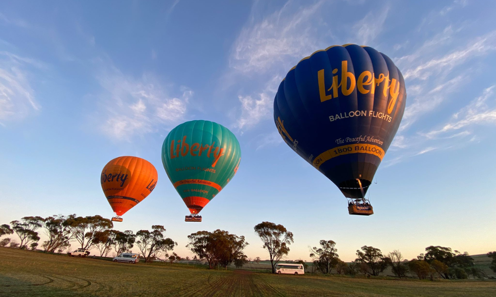 Balloons flying over the misty Avon Valley river near Perth at dawn